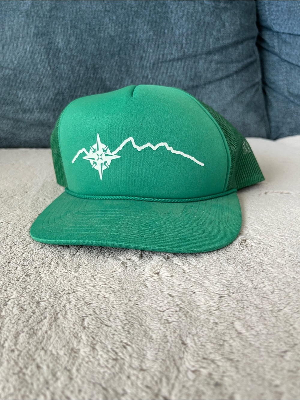 Green Hat with a White Mountain & Compass Graphic